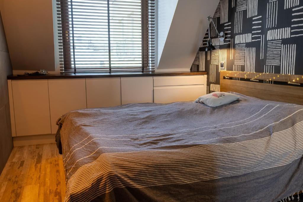a bedroom with a bed and a large window at Loft Świetego Mikołaja - Blisko Rynku - Klimatyzacja in Wrocław