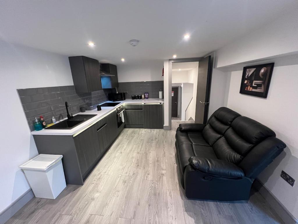 a living room with a couch and a kitchen at 1 Bedroom Lavish Studio Apartment in Bradford