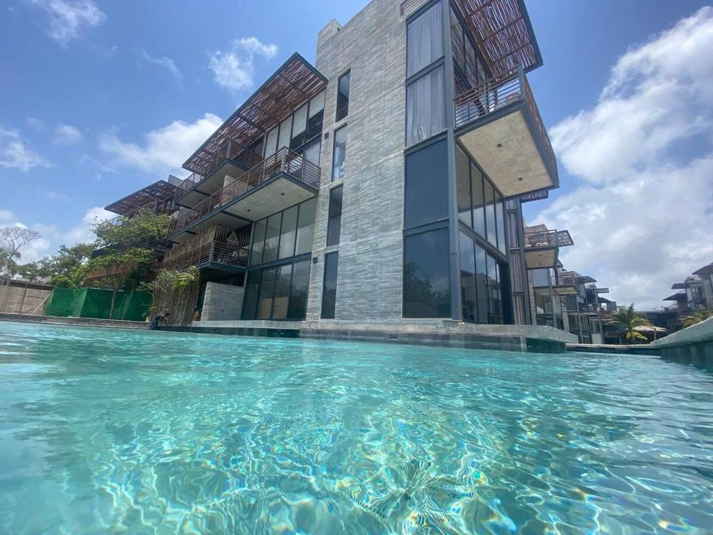a building with a pool of water in front of it at Eco chic apartment in Tulum in Tulum
