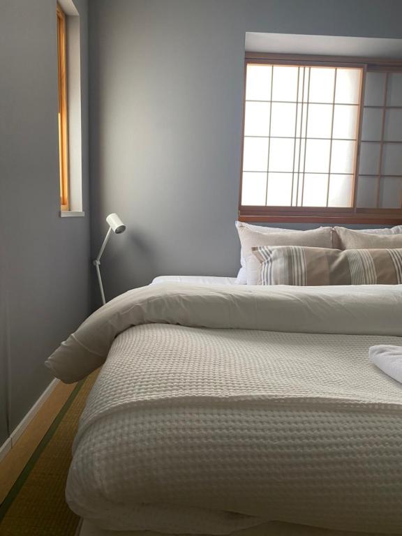 una camera da letto con due letti e una finestra di Myoko Forest Lodge a Myoko