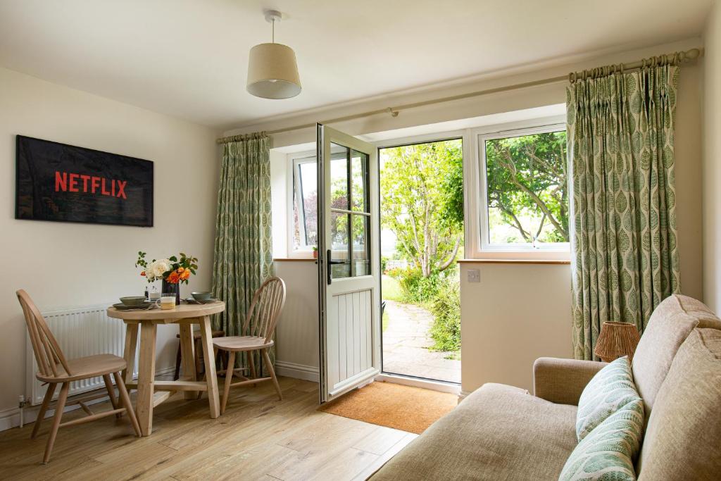 a living room with a couch and a table at Wychwood Cottage in Charlbury