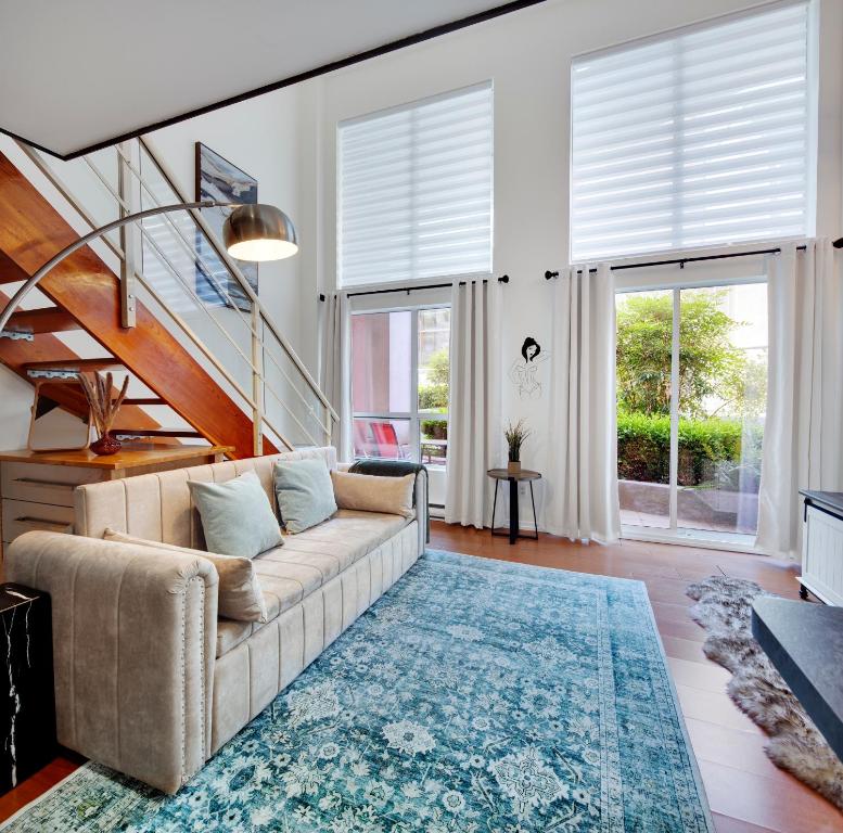 un salon avec un canapé et un escalier dans l'établissement Cozy Two-story Loft in Downtown, à Vancouver
