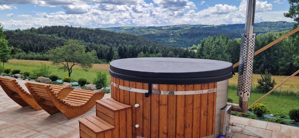 a hot tub on a patio with a view of a mountain at Wzgórze Wadery Siekierczyna in Siekierczyna