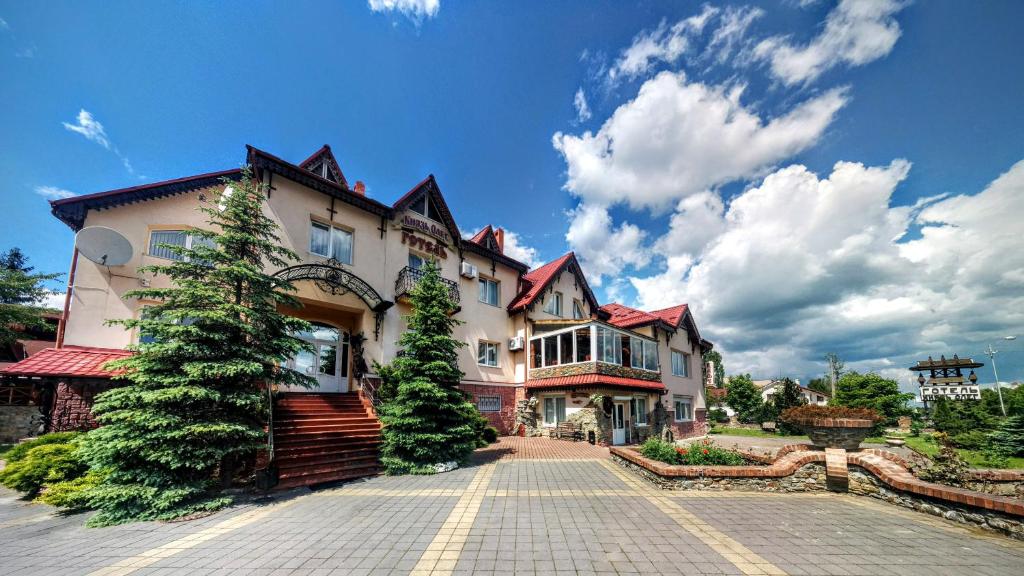 a large house with trees in front of it at Hotel Complex Knyaz Oleg in Dolyna