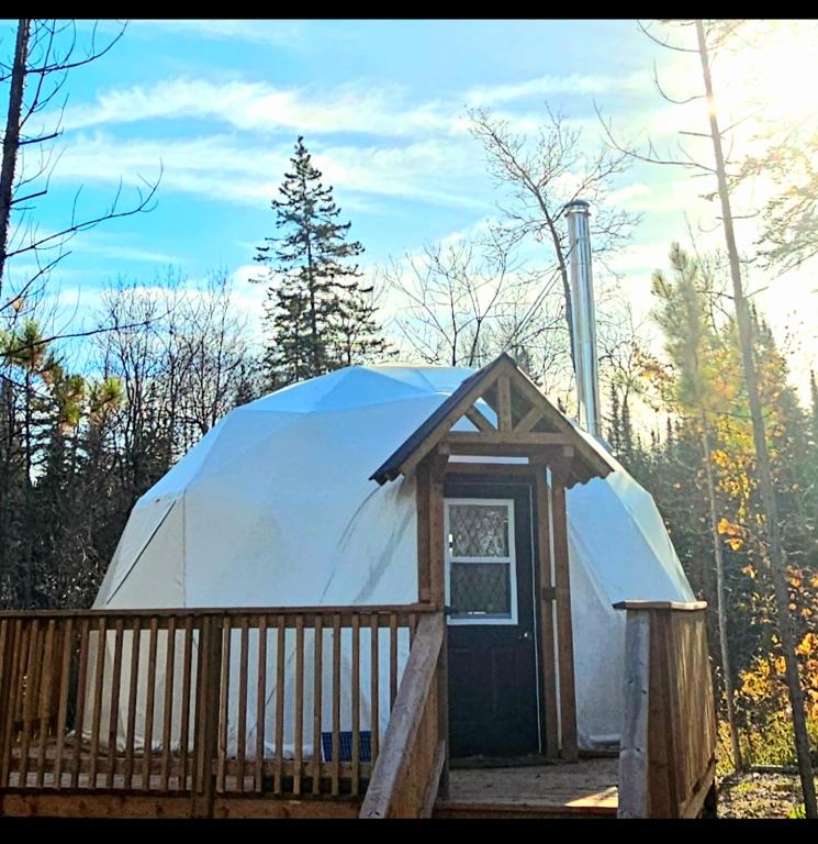 a large dome tent with a wooden porch at Glamping with the Stars, Aquarius in Hadashville