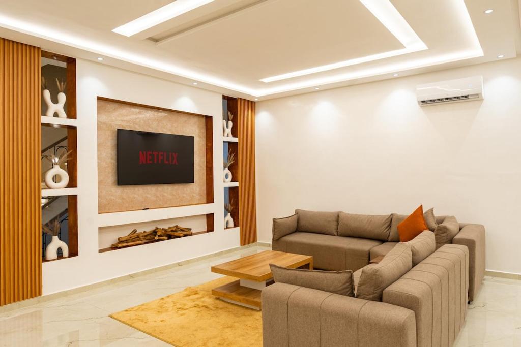 a living room with a couch and a tv at Petit Palm in El Rhechat