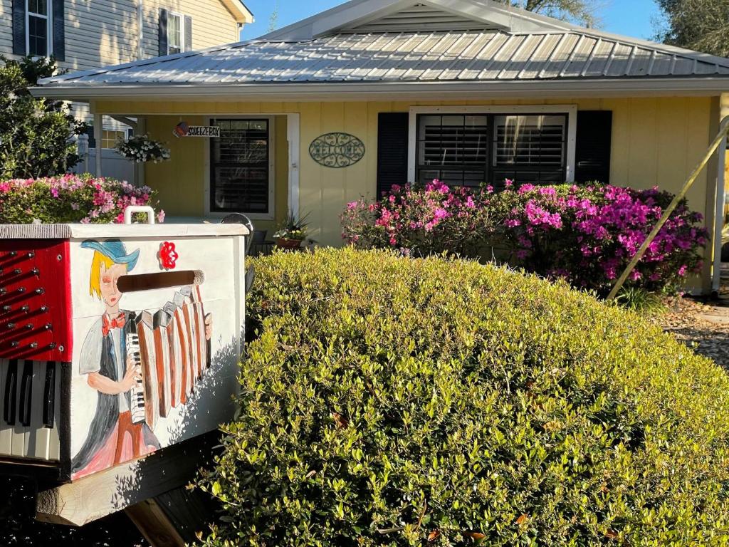 a house with a sign in front of it at The Squeezebox in Saint Simons Island