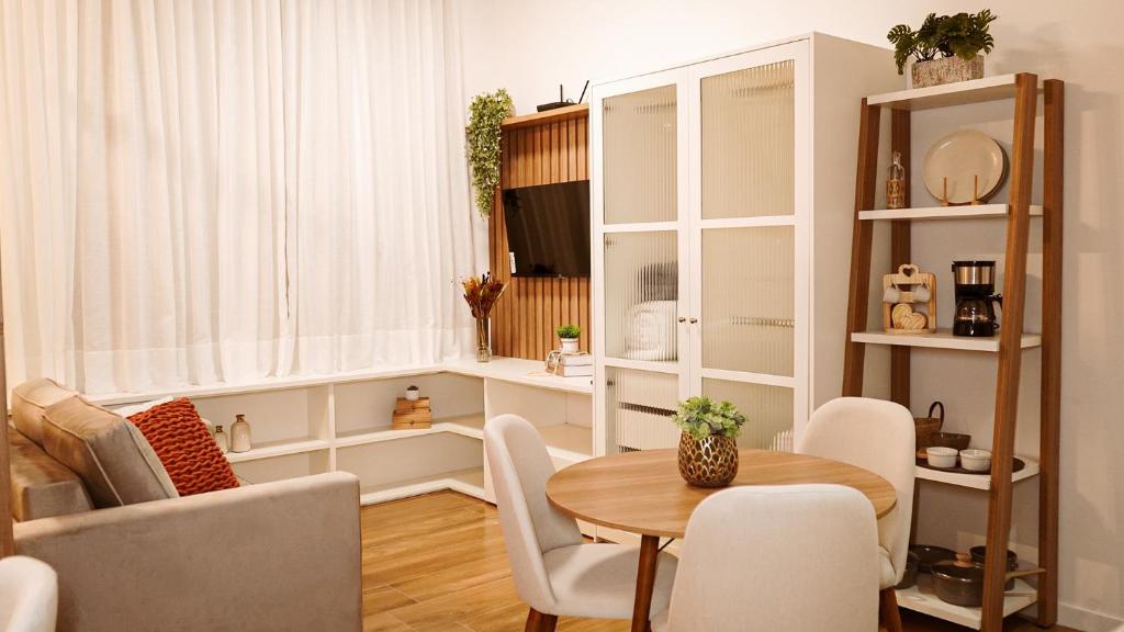 a living room with a table and chairs at FLAT NOVO e ACONCHEGANTE in Ribeirão Preto