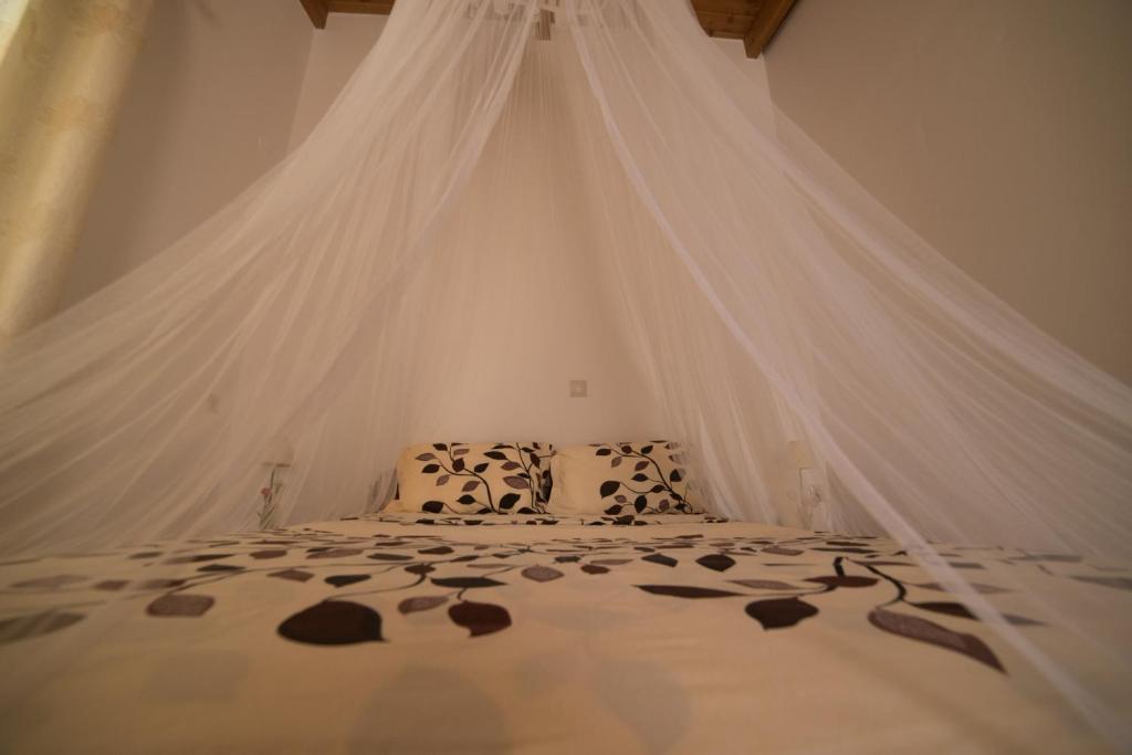 Schlafzimmer mit einem Bett mit Moskitonetz in der Unterkunft Bodikos Villas & Apartments in Pitsidia