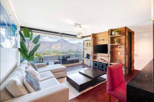 a living room with a couch and a table at SkyView Manquehue in Santiago