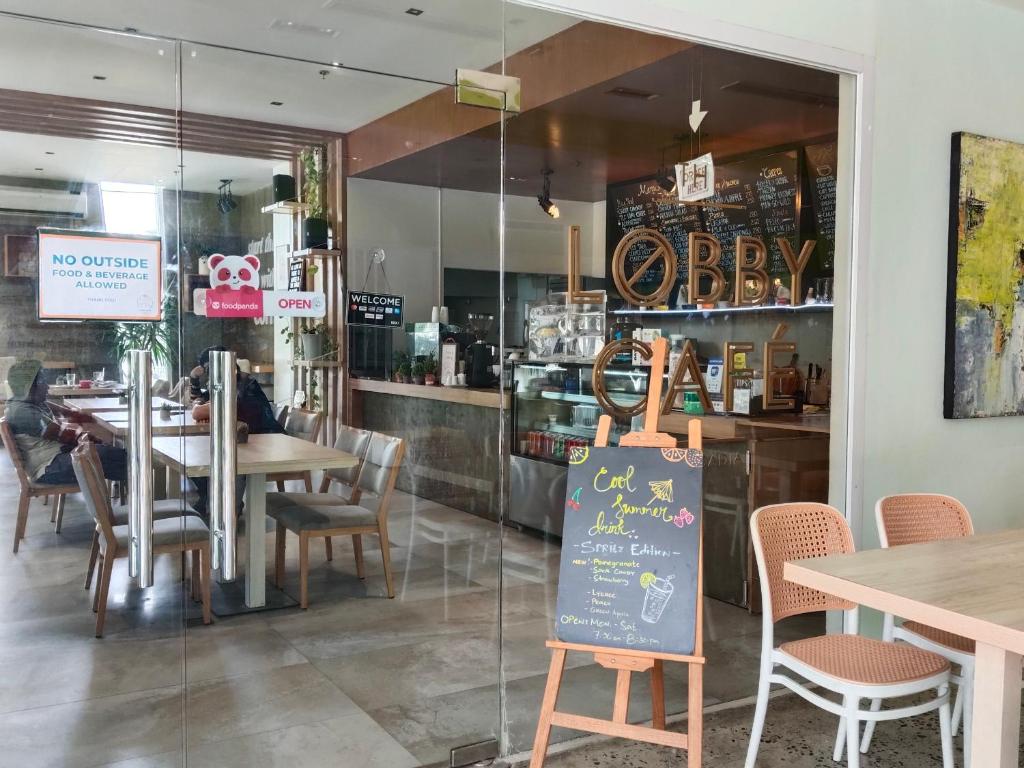 a restaurant with tables and chairs and a sign in the window at Matina Enclaves Bldg D 2Bedroom with balcony and view in Davao City