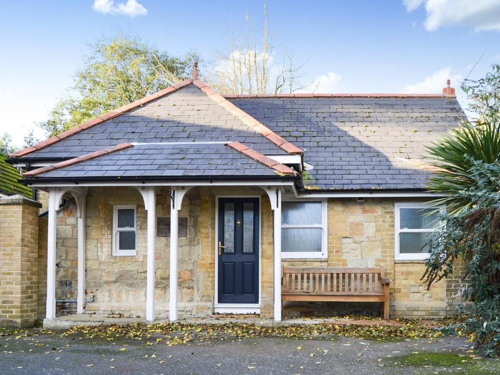 Una casa de ladrillo con un banco delante de ella. en Steephill Lodge, en Saint Lawrence