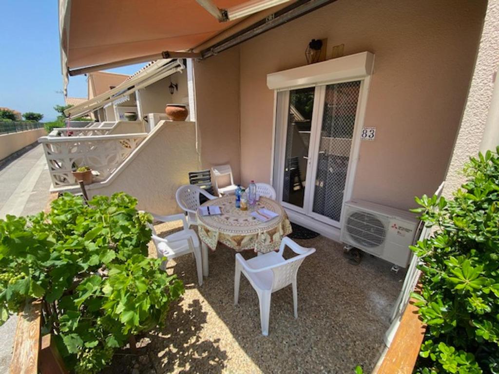 un patio avec une table et des chaises sur un balcon dans l'établissement Port Leucate: Charmante Villa 4 Pers. Proche Lac, Terrasse, Parking, Animaux Acceptés - FR-1-798-49, à Leucate