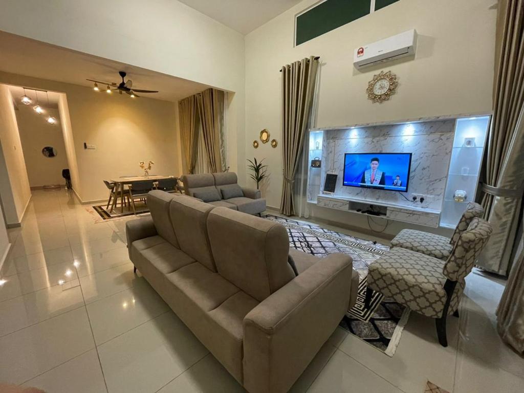 a living room with a couch and a flat screen tv at BULAN Homestay Melaka in Melaka