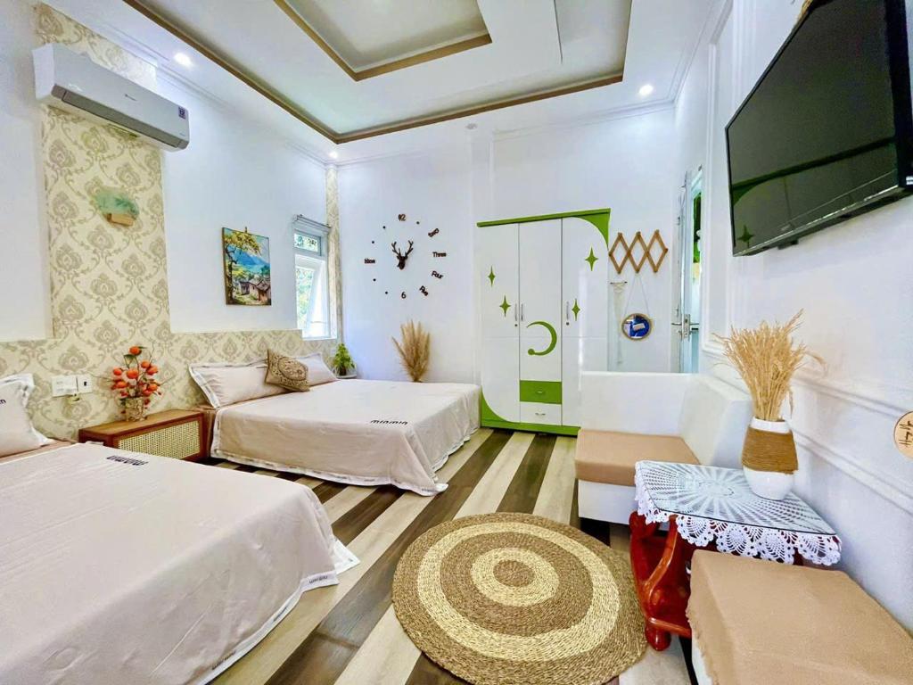 a living room with two beds and a tv at Hoàng Nga 2 Homestay in Phan Thiet