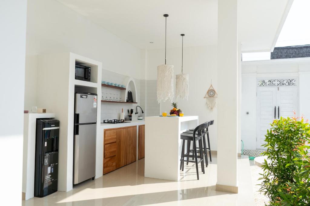 cocina blanca con nevera y encimera en Villa Azula Bali, en Canggu