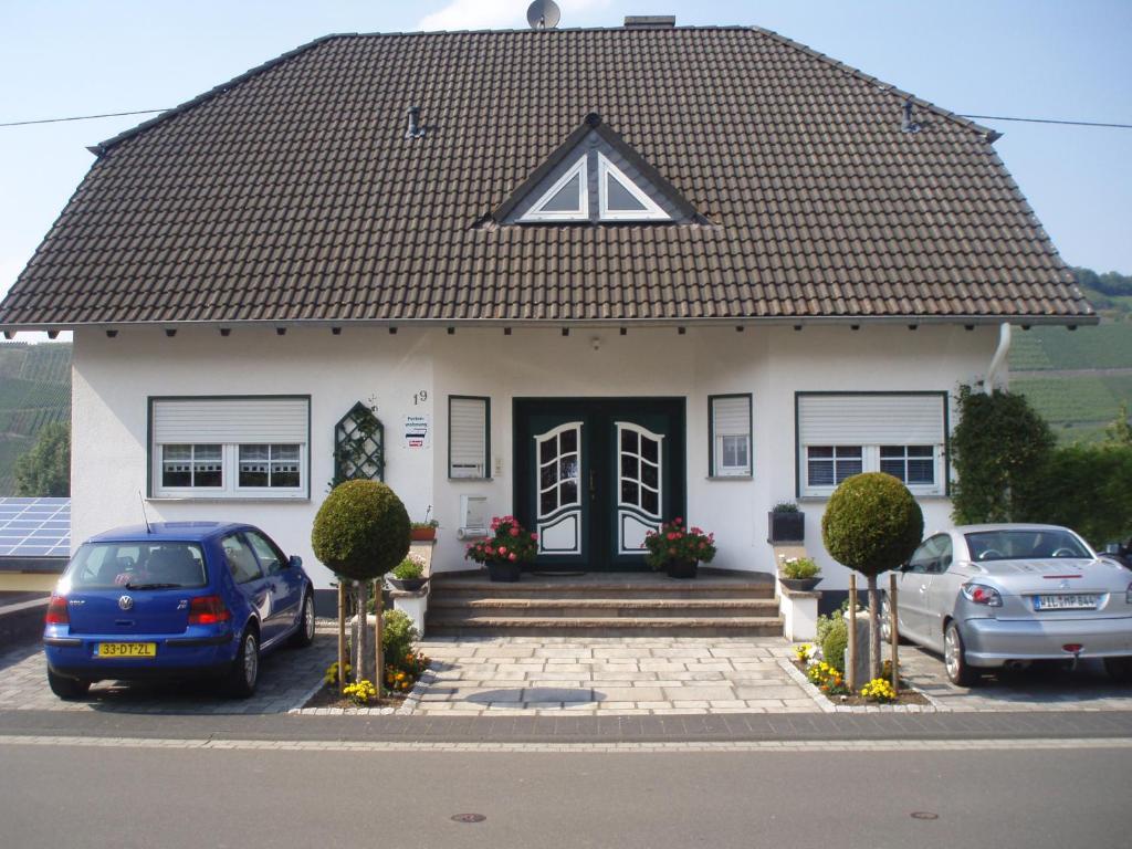 a white house with an a sign on the roof at Landhaus Martina in Brauneberg