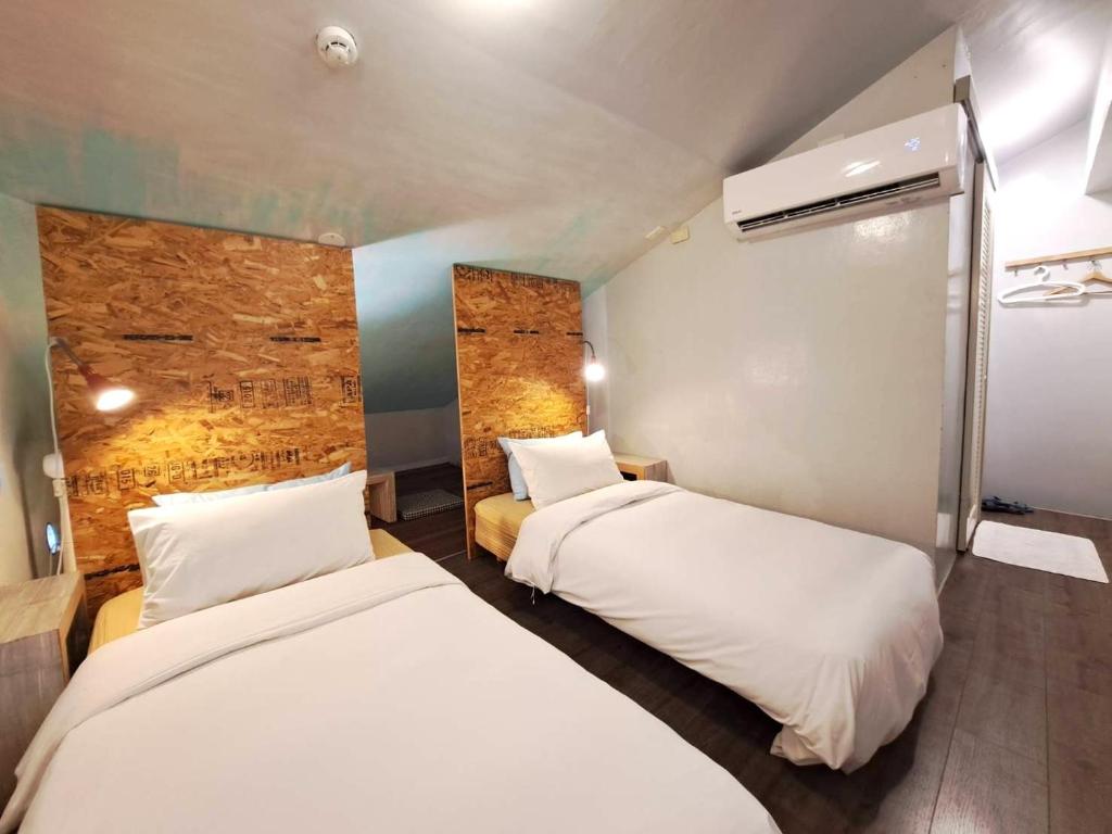 Postel nebo postele na pokoji v ubytování 墾丁橘月Orange Moon Inn