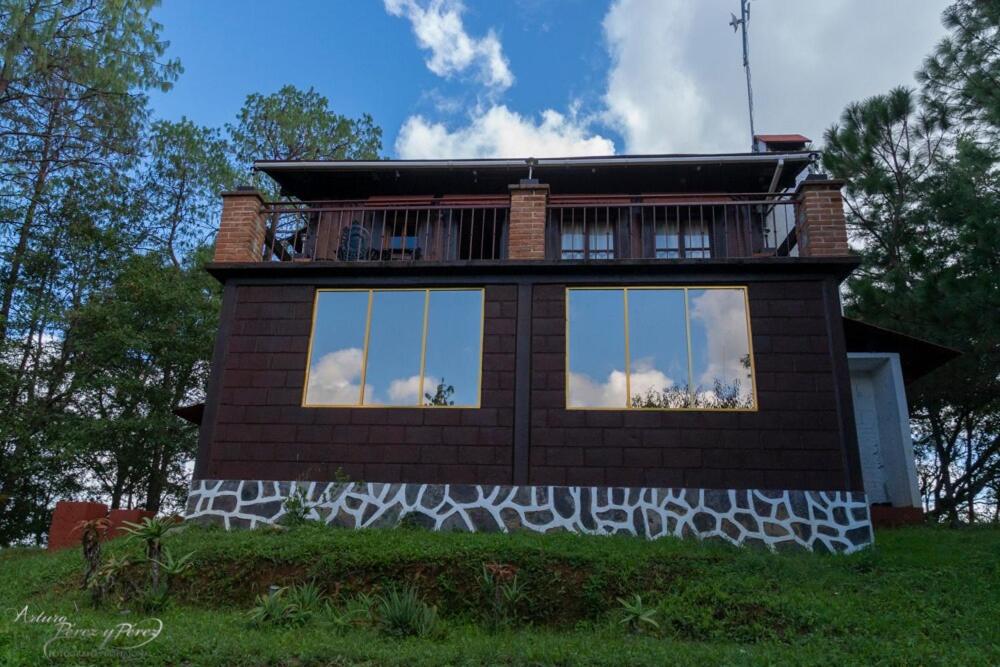 a house with a balcony on the side of it at Cabaña Vista al Cielo - Cabañas Terrazul in Pinal de Amoles