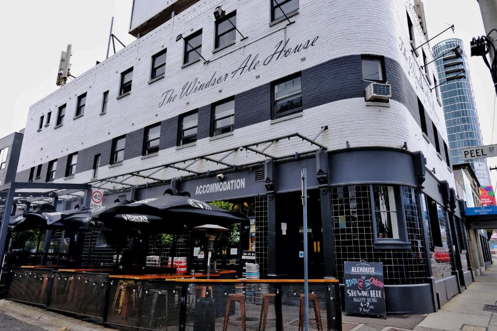 un edificio con una sombrilla delante de él en Pint On Punt Backpackers, en Melbourne