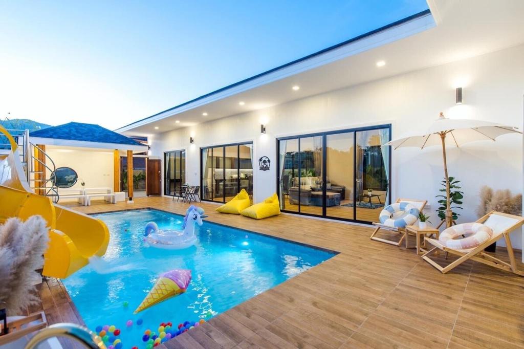 een huis met een zwembad met een zwembadnoedelbad bij V2 Poolvilla Cha-am Huahin in Ban Hup Kaphong