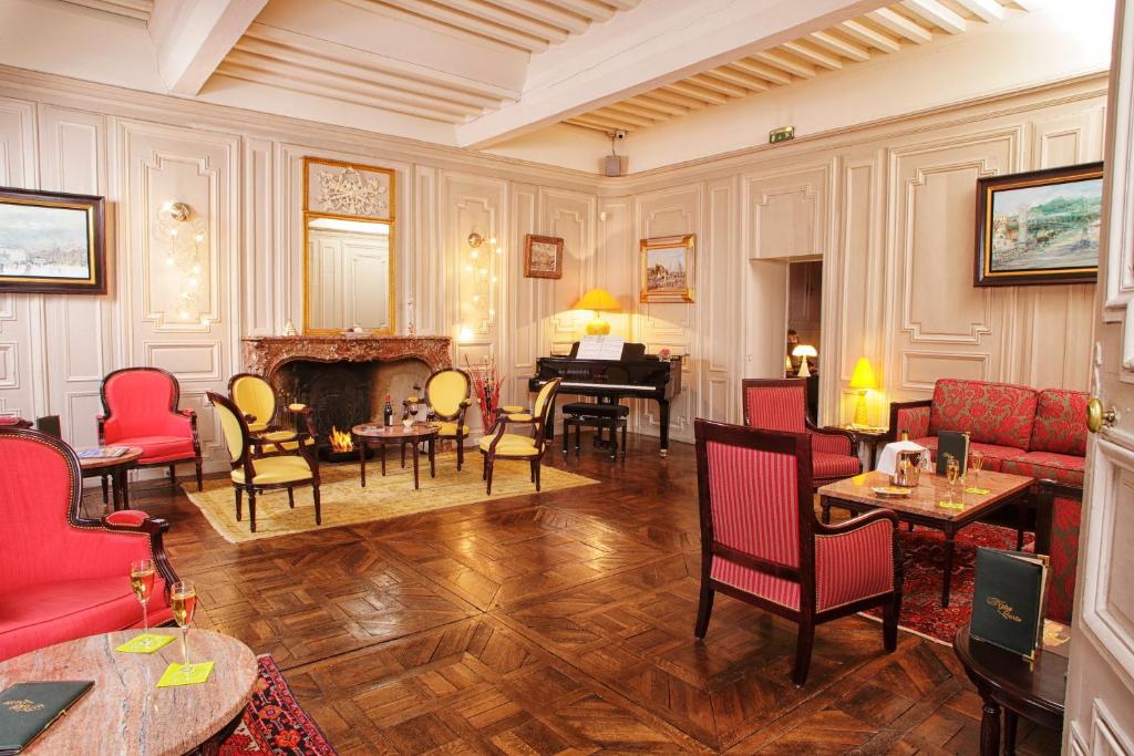 a living room with red chairs and a fireplace at Hotel D&#39;haussonville in Nancy