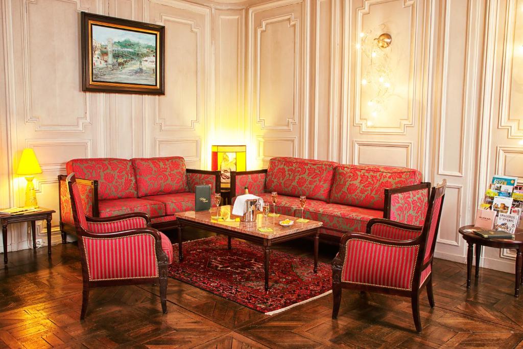 a living room with a red couch and a table at Hotel D&#39;haussonville in Nancy