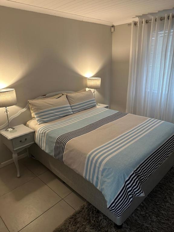 a bedroom with a bed with a striped bedspread at Cozy at Cedarwood in Oakdale