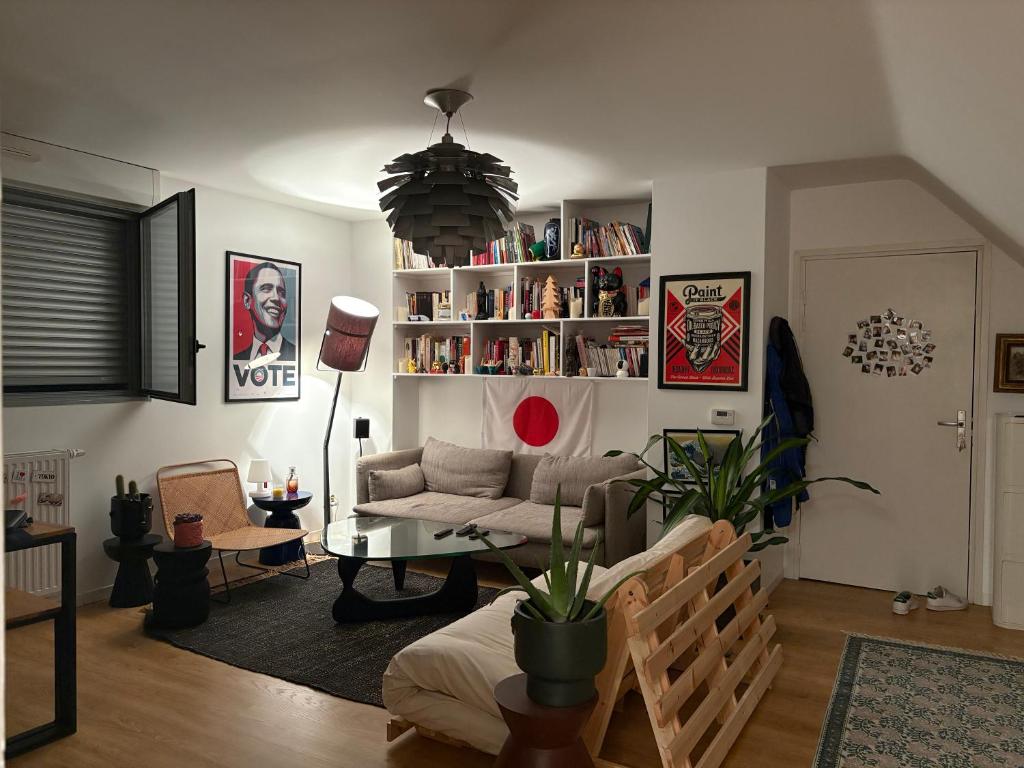 un salon avec un canapé et une table dans l'établissement Appartement sous les toits BX Bastide, à Bordeaux