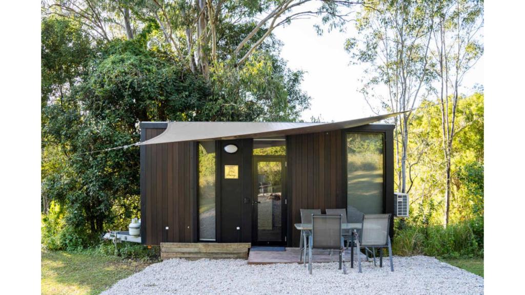 eine kleine Hütte mit einem Tisch und Stühlen in der Unterkunft Hill Creek Tiny House 4 by Tiny Away in Perwillowen