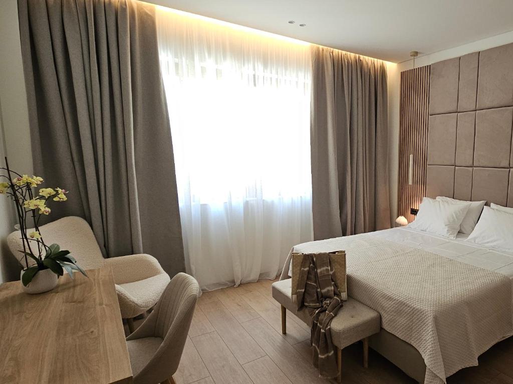 ein Schlafzimmer mit einem Bett und einem Tisch und einem Fenster in der Unterkunft S & E luxury city residences in Rhodos (Stadt)