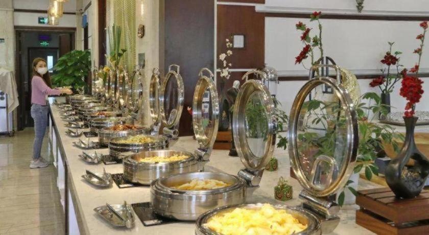 a buffet line with bowls of food on a table at Argyle International Airport Hotel Shanghai in Shanghai