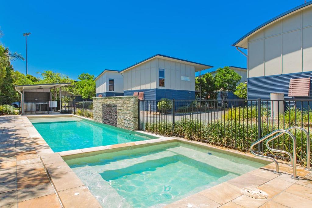 a swimming pool in front of a house at Beach Shacks 1 240m to Beach with Pool, Spa and Bbq in Casuarina