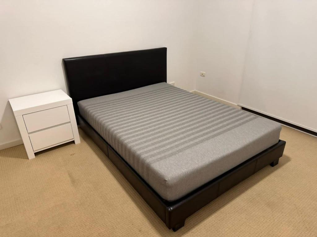 a bedroom with a bed and a night stand at Town house Room with Shared Bath in Capalaba