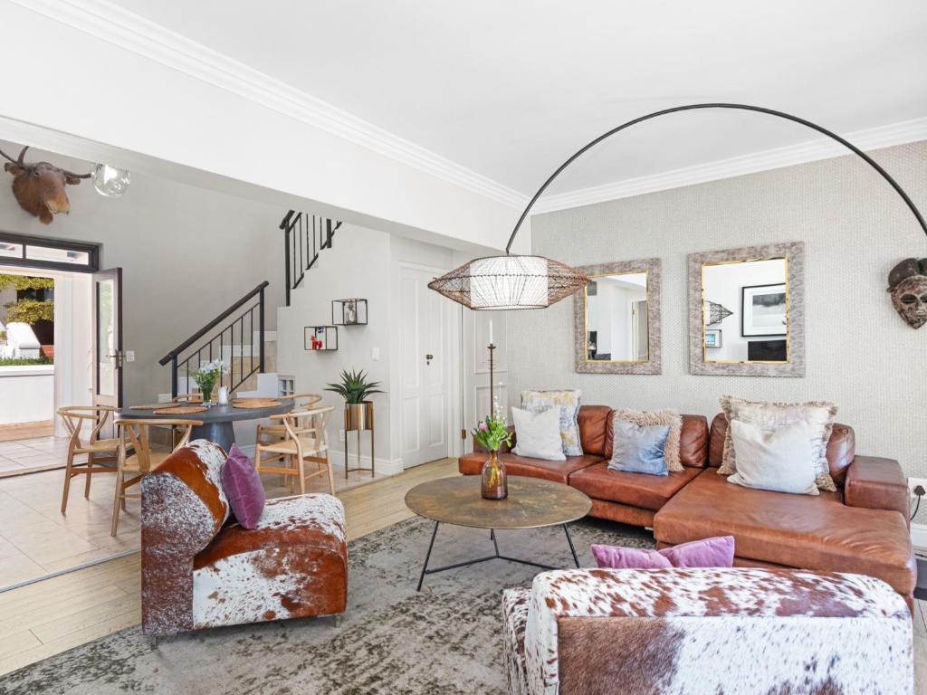 a living room with a couch and chairs and a table at Winelands Golf Lodges 2 in Stellenbosch