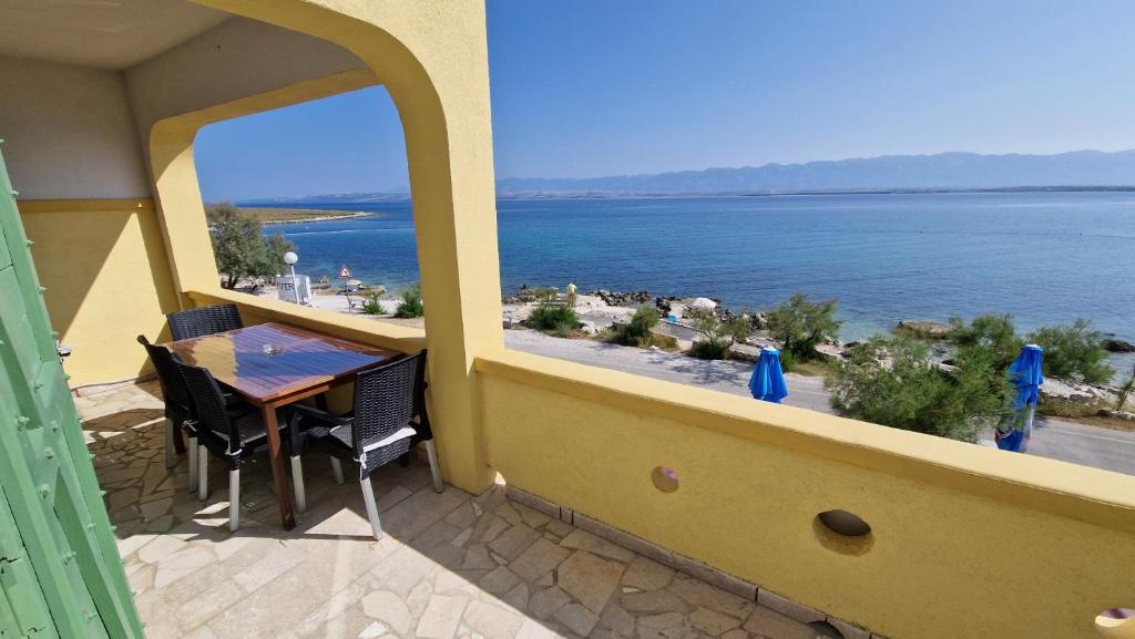 balkon ze stołem i widokiem na ocean w obiekcie Apartmani Kod Barbe w mieście Vir