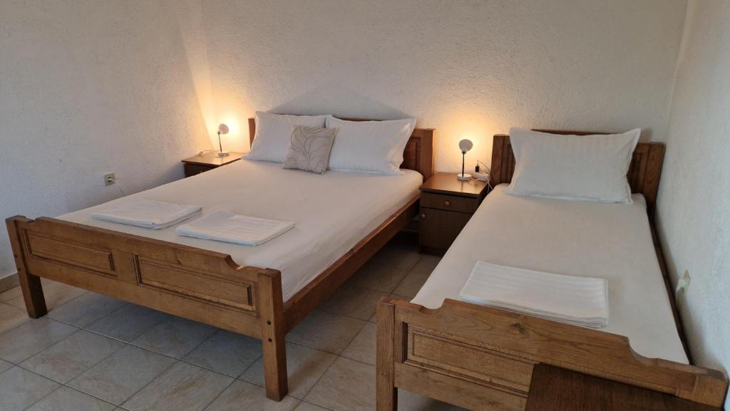 dwa łóżka w pokoju z dwoma lampami na stołach w obiekcie Apartmani Kod Barbe w mieście Vir