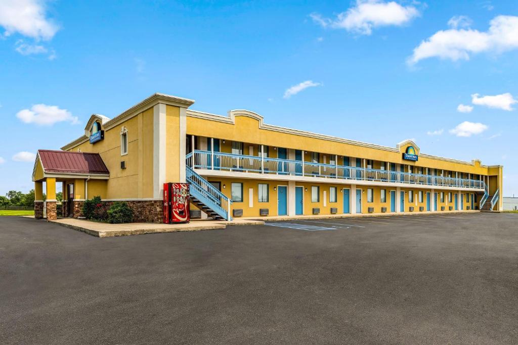 a large yellow building with a parking lot at Days Inn by Wyndham Fort Wayne in Fort Wayne