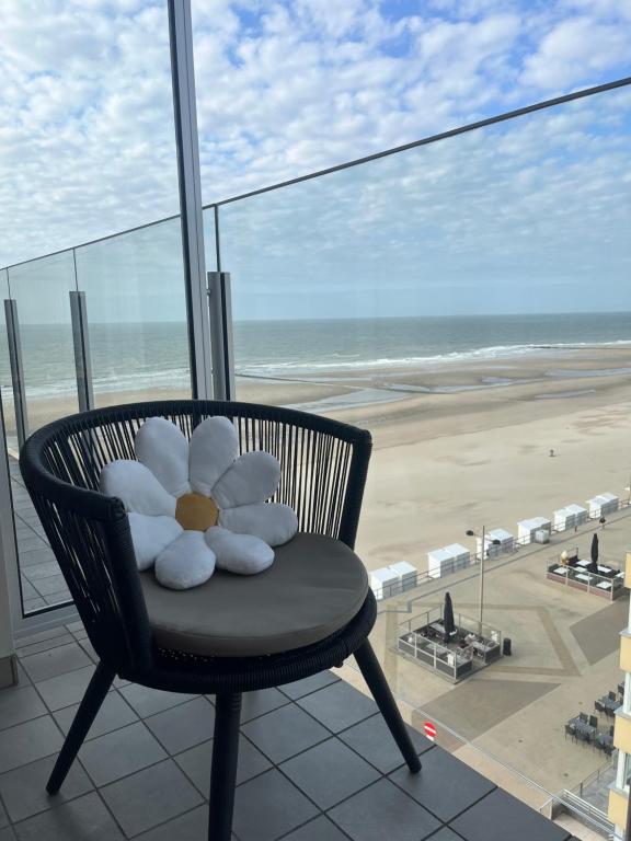 une chaise avec un animal en peluche dessus devant une plage dans l'établissement An's seaview Middelkerke, à Middelkerke