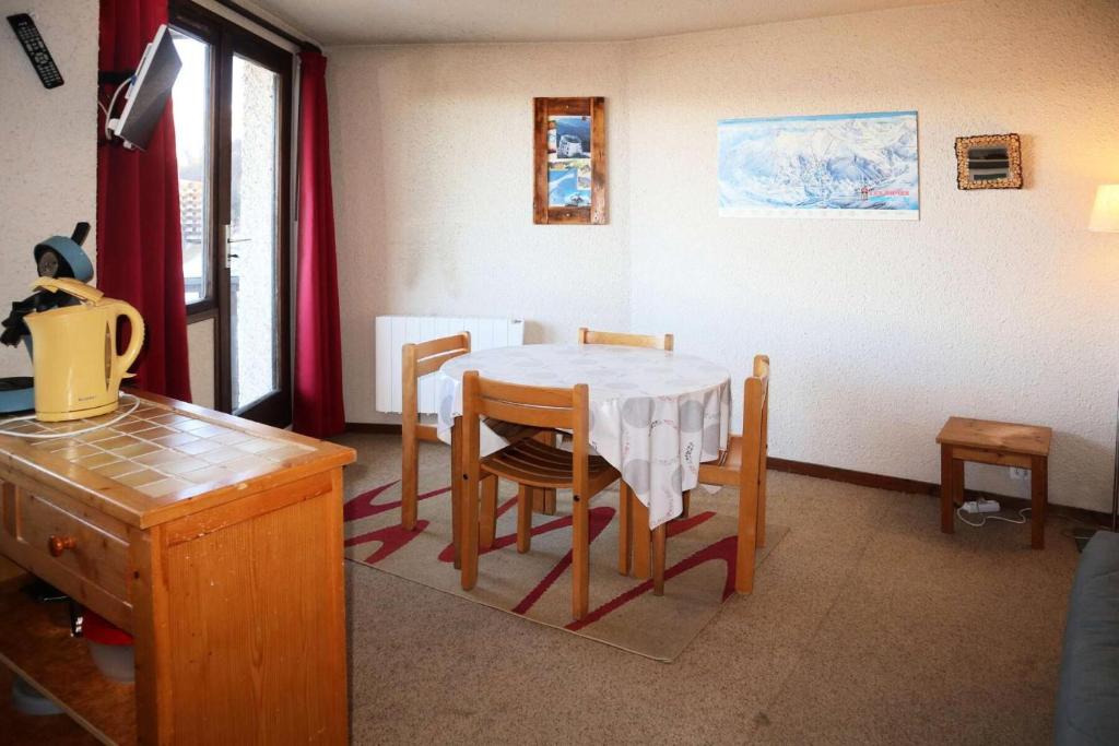 une cuisine avec une table et des chaises dans une pièce dans l'établissement Résidence Le Cairn - STUDIO 4 PERSONNES CENTRE STATION MAE-3821, aux Orres