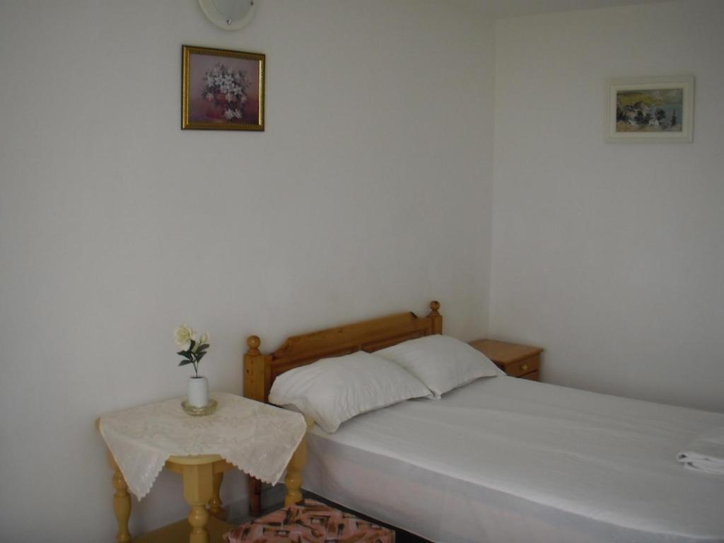 1 dormitorio con 1 cama y mesa auxiliar en Guest house Horizont, en Balchik