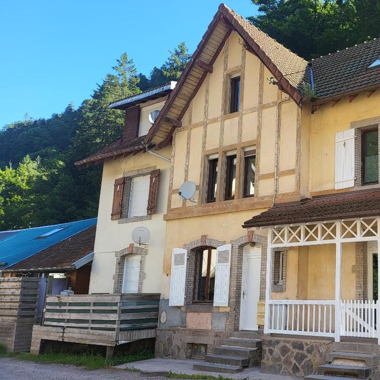 une vieille maison jaune avec des portes et des fenêtres blanches dans l'établissement Maison kerthoff 41D, à Gérardmer