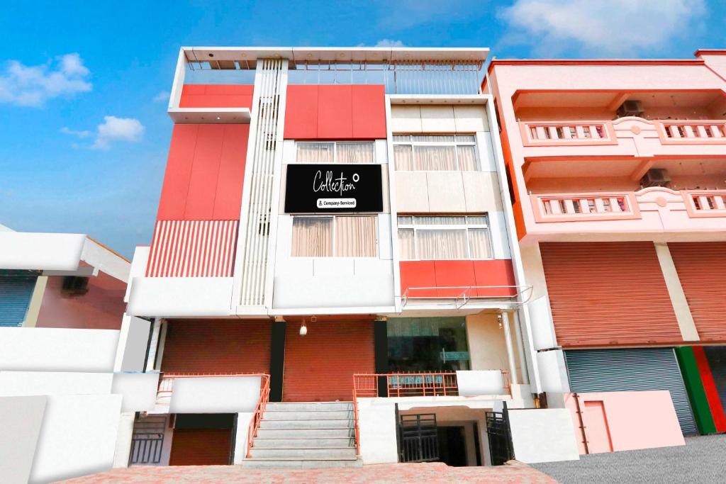 a red and white building with a black sign on it at Collection O MVP Double Road in Visakhapatnam