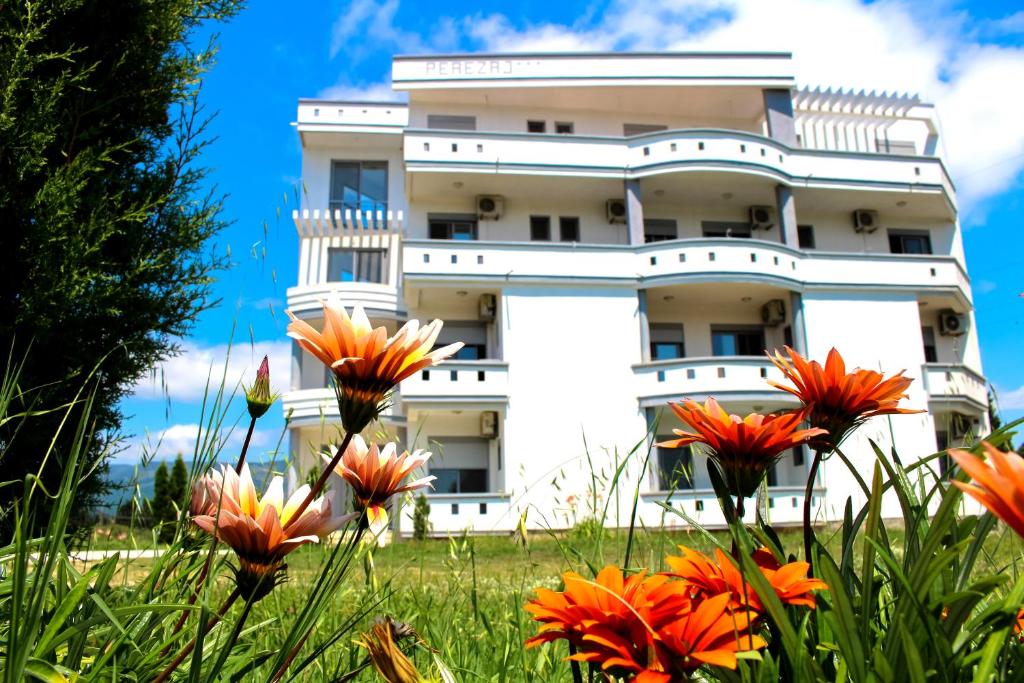 un edificio blanco con flores delante en Apartments Perezaj II, en Ulcinj