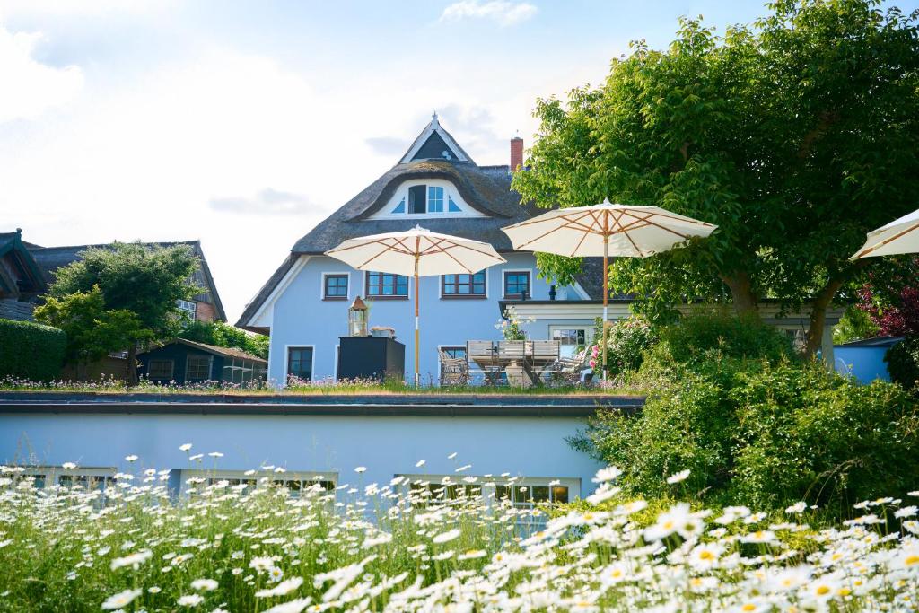 a blue house with two umbrellas in front of it at Landhaus Esperort in Ahrenshoop
