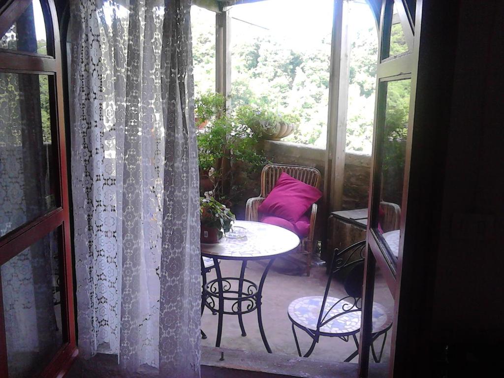 um pátio com uma mesa e cadeiras e uma janela em Casa Sulla Rupe em Calcata