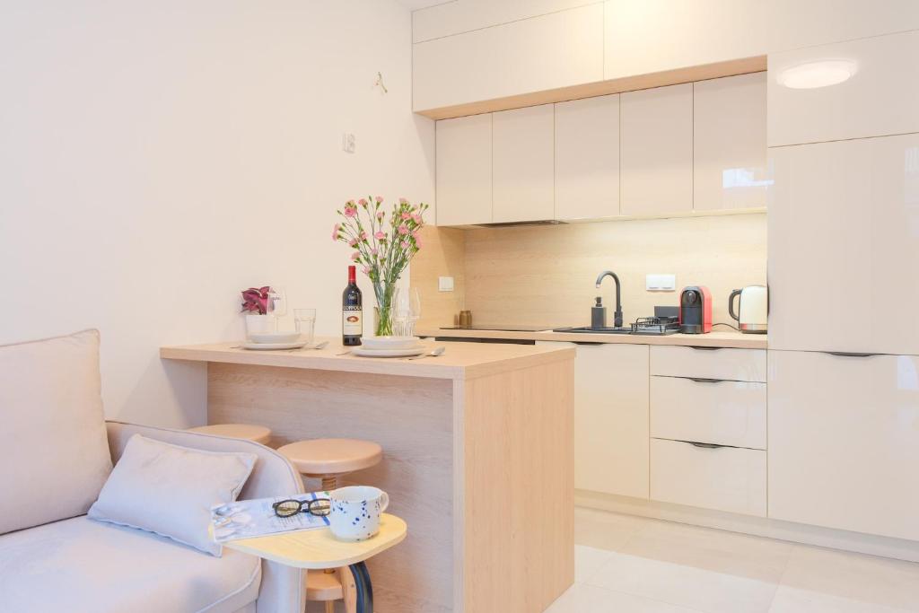 Una sala de estar con un sofá y una cocina. en Laguna Beskidów Resort - Studio Comfort, en Zarzecze
