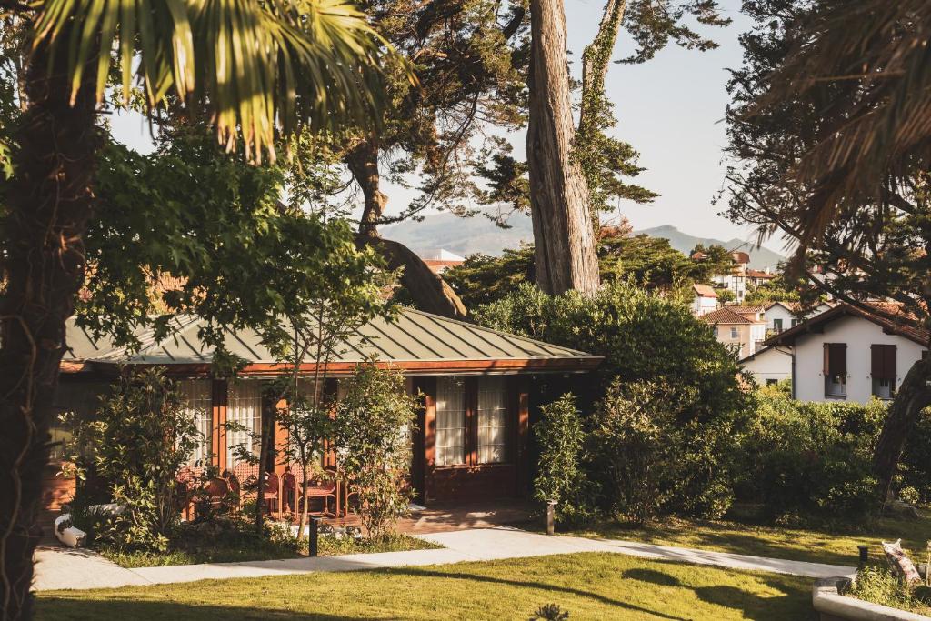 a house in a garden with trees at Parc Victoria Appartements in Saint-Jean-de-Luz