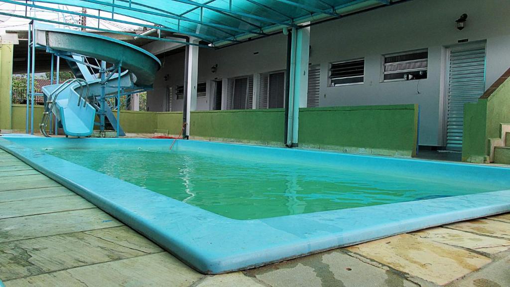 an empty swimming pool with a water slide at Suítes Recanto Renascer in Caraguatatuba