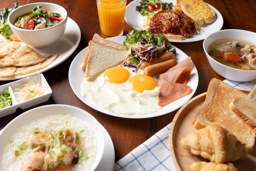 A spread of hot breakfast plates, toast, fruit and juice.